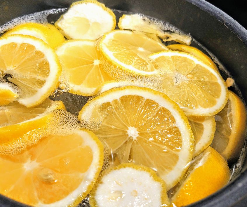 Slices of bright yellow lemons in a large pot.