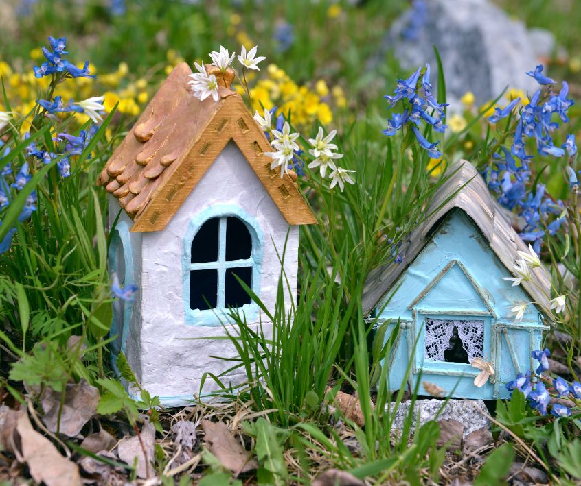 Two tiny fairy houses in spring flowers.