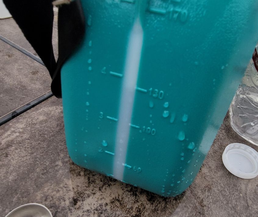 Volume gauge on the side of a green garden sprayer reservoir.