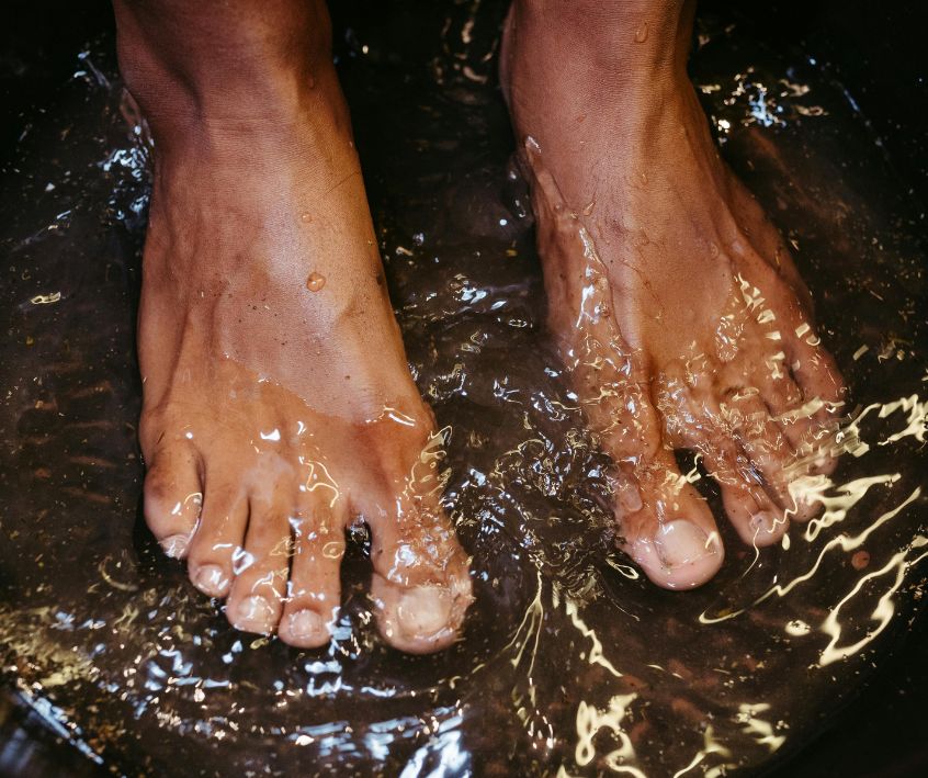 A person soaking their feet in a large bowl of water.